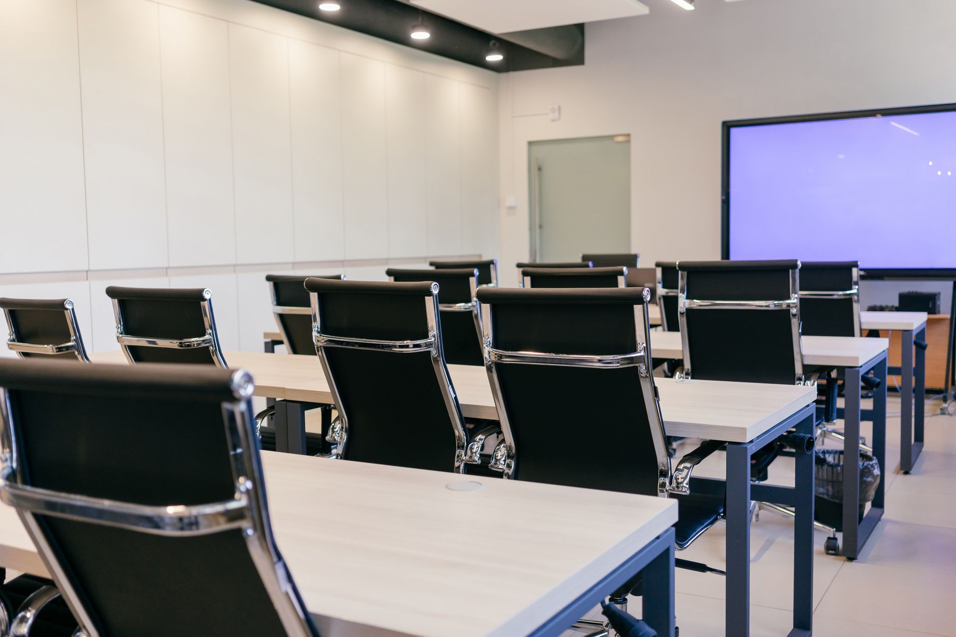 Spacious lecture hall with rows of seats and a projection screen